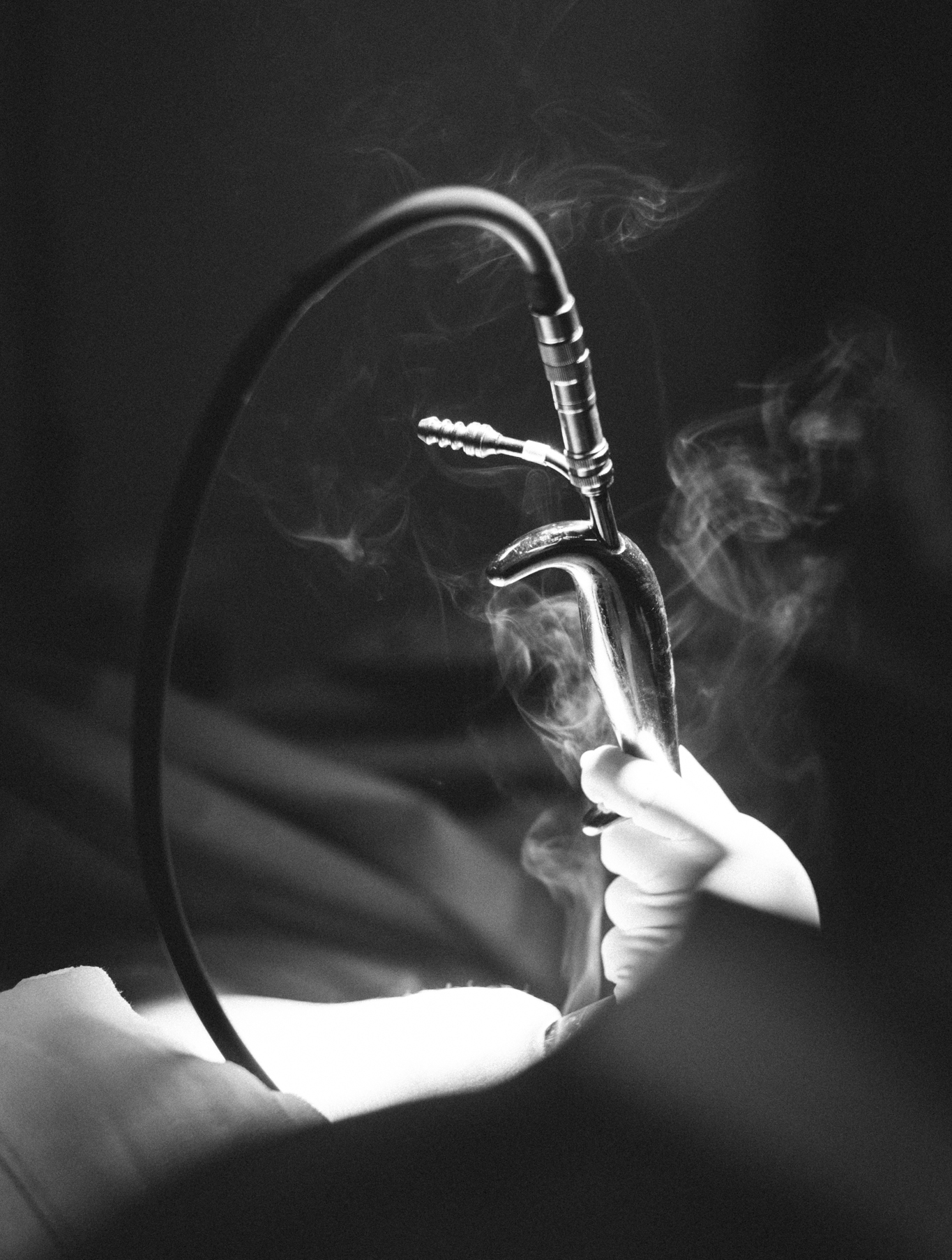 Black and white photo of doctors performing plastic surgery. Photography by Laura Divella