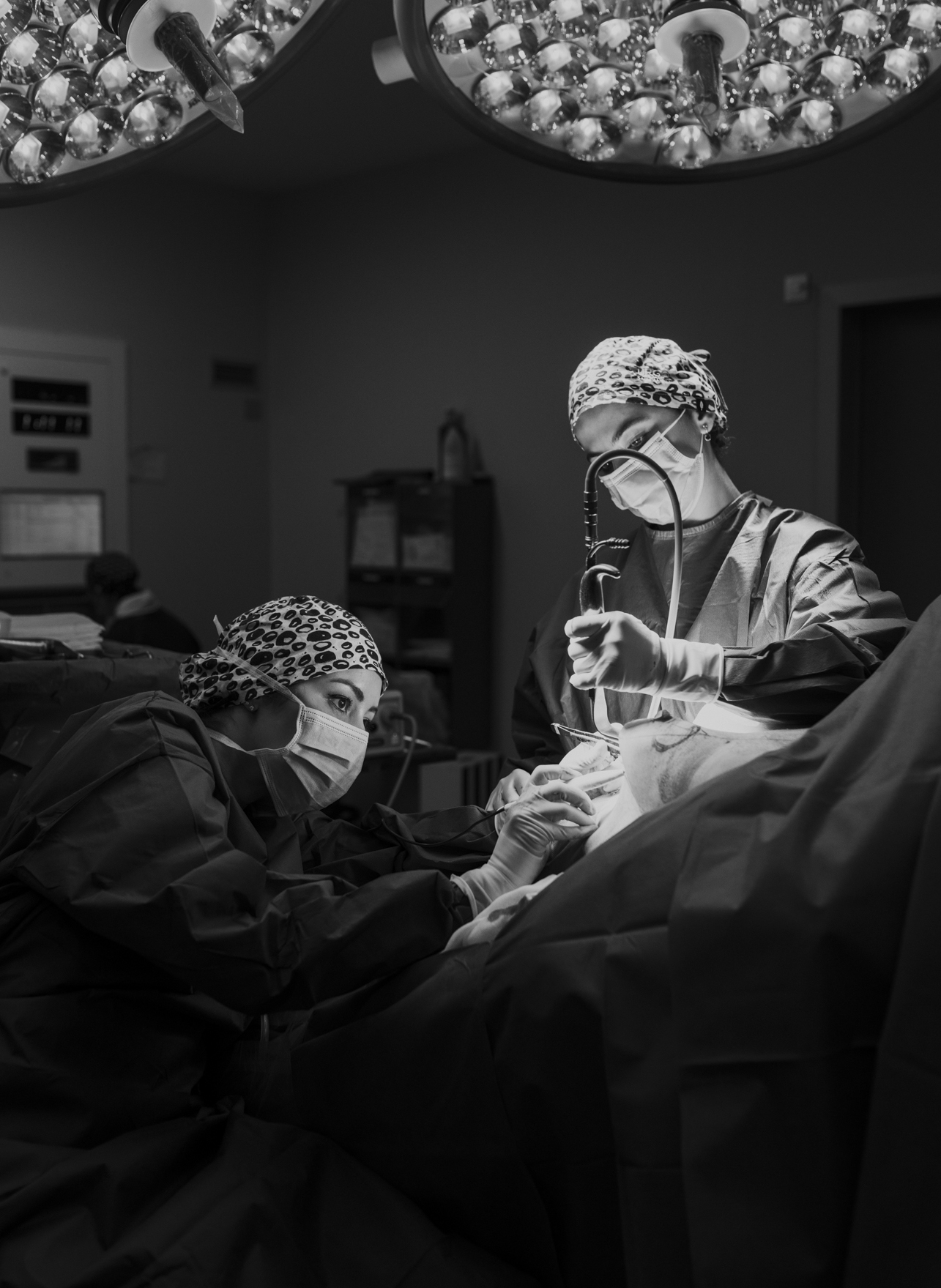 Black and white photo of doctors performing surgery. Photography by Laura Divella