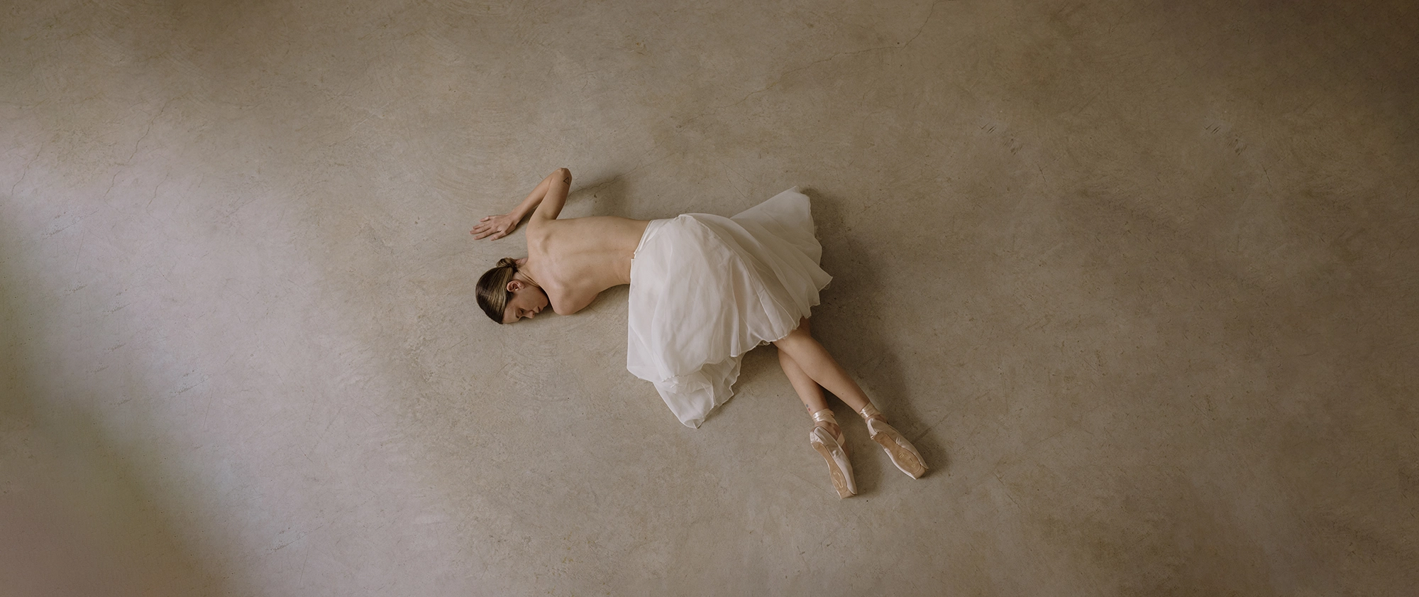 ballet dancer on the floor wearing ballet shoes